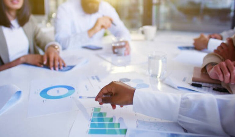 Interfaith leaders in a meeting with financial charts