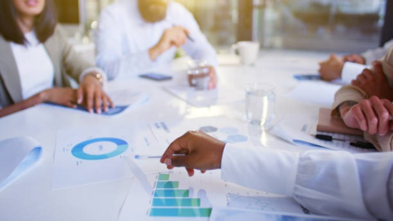 Interfaith leaders in a meeting with financial charts